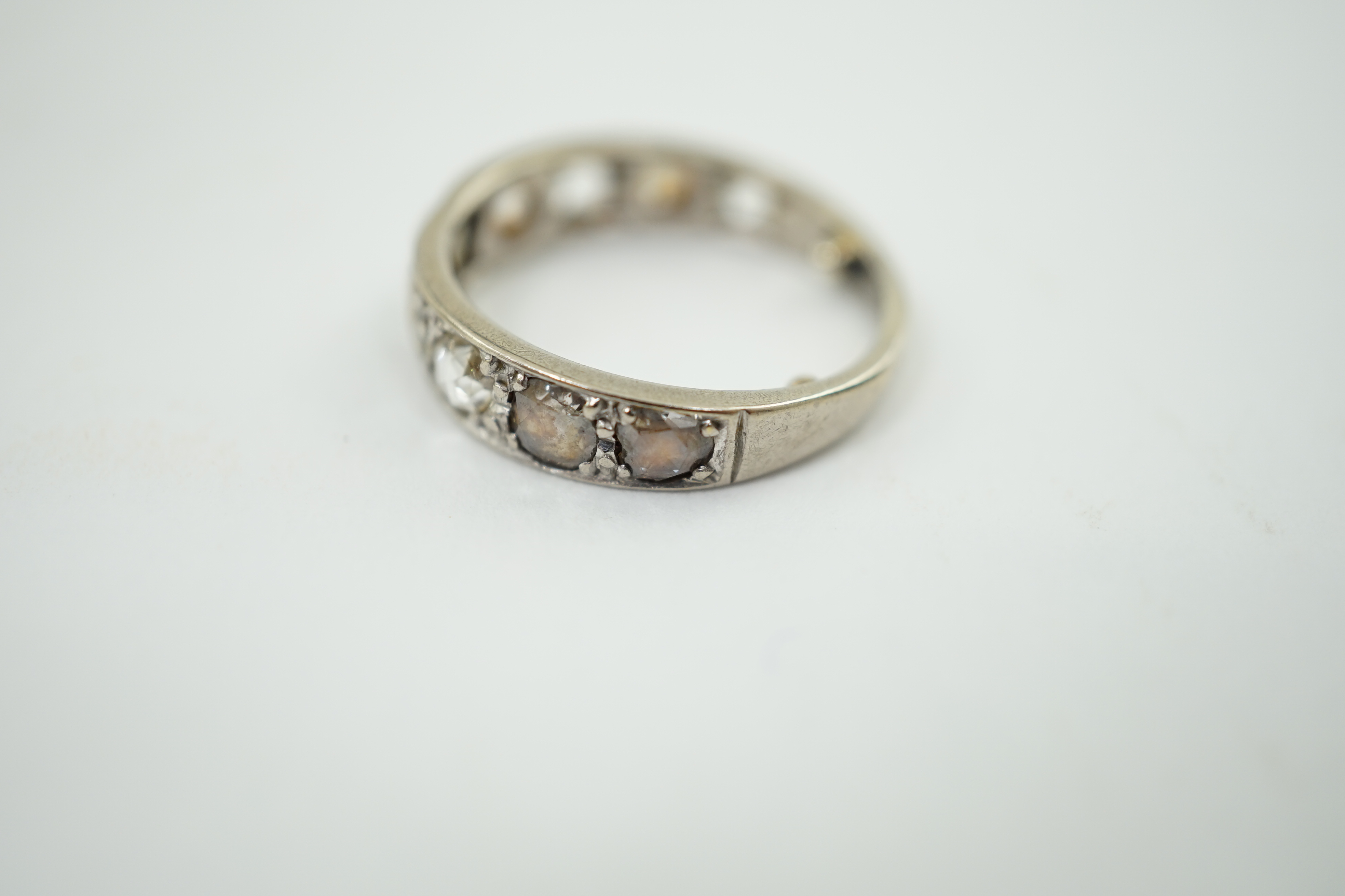 A white gold and nine stone graduated rose cut diamond set half hoop ring